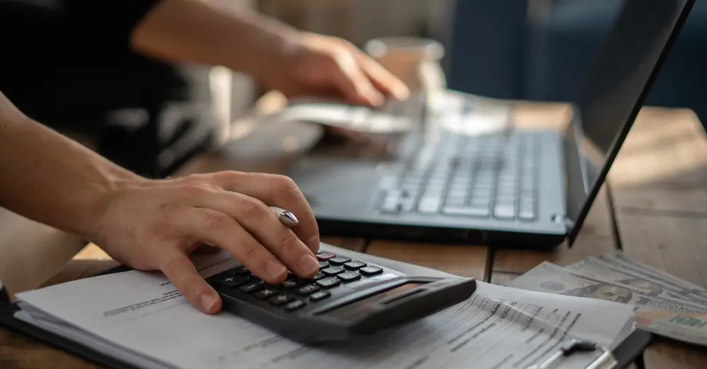 Calculating overheads using a calculator and a laptop